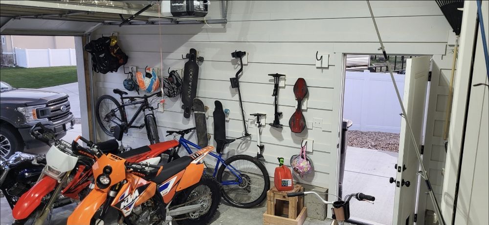 Same garage after Goat Garages installed a locking cleat wall with bikes, boards and gear hung neatly