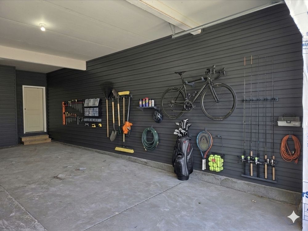 Same garage finished with a dark graphite locking cleat wall holding a road bike, golf clubs, fishing rods and tools